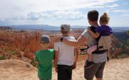Eine Familie steht am Rand einer Schlucht und bewundert die beeindruckende Landschaft von Bryce Canyon.