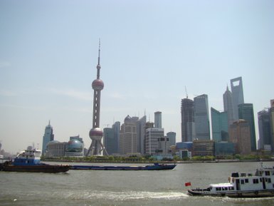Fähren passieren die Skyline von Pudong auf dem Huangpu-Fluss – China mit Kindern