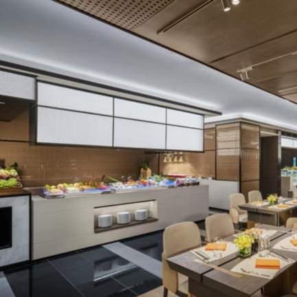 Ein eleganter Essbereich mit modernen Tischen, frischen Früchten und einem stilvollen Buffet im Hintergrund.