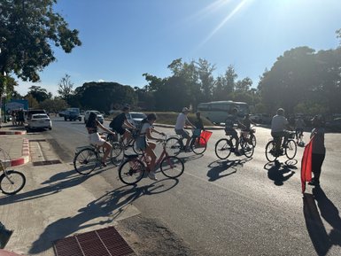Menschen erkunden mit dem Fahrrad die Tempelanlage Wat Mahathat in Sukhothai - Thailandreise mit Kindern