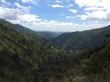 Saftig grüne Hügellandschaft mit Bergen – Sri Lanka Familienreise