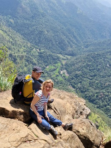 Zwei Teenager sitzen auf einem Felsen und blicken in die grüne Landschaft bei Ella – Sri Lanka mit Kindern