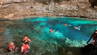 Familie mit Kindern schwimmt gemeinsam in einer natürlichen Cenote – Mexiko Reise mit Kindern