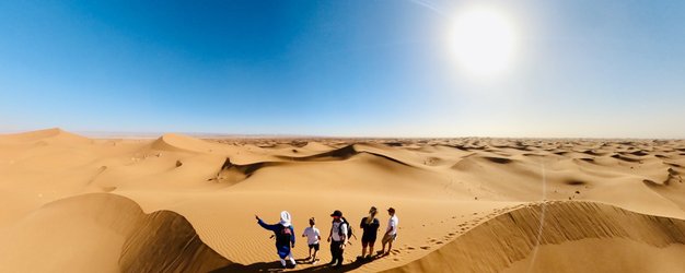 Familie steht in Sanddünen der Sahara - Marokko mit Kindern