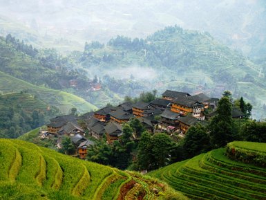 Panorama der Reisterrassen von Longsheng mit Blick auf traditionelle Holzhäuser – China Familienreise