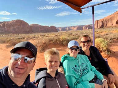 Eine Familie genießt eine Jeep-Tour durch die beeindruckende Landschaft von Monument Valley, umgeben von roten Felsen.