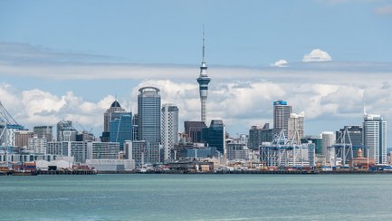 Die beeindruckende Skyline von Auckland zeigt moderne Wolkenkratzer und den ikonischen Sky Tower unter einem klaren Himmel.