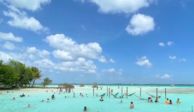 Familien genießen das Schwimmen im klaren Wasser der Lagune von Bacalar – Mexiko Familienreise