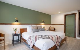 Ein stilvolles Zimmer mit einem großen, einladenden Bett, dekoriert mit einer roten und weißen Decke.