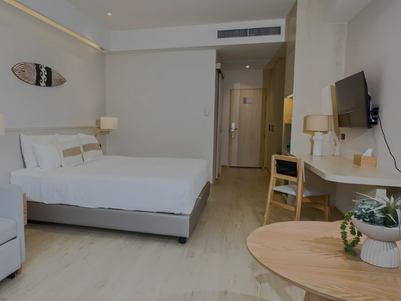 Ein modernes Hotelzimmer mit einem großen Bett, einem gemütlichen Sofa und einem stilvollen Tisch, ideal für Entspannung.