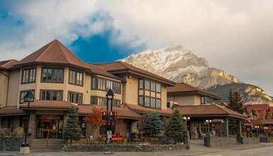 Das Elk Avenue Hotel präsentiert sich mit einer charmanten Fassade und Blick auf majestätische Berge im Hintergrund.