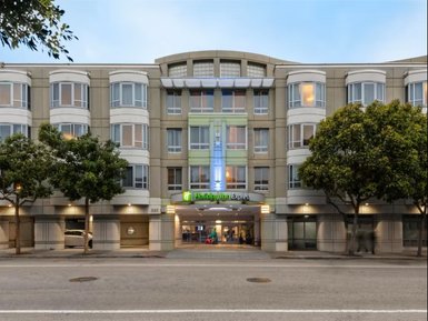 Das Holiday Inn Express in San Francisco zeigt eine moderne Fassade mit großen Fenstern und grünen Akzenten.