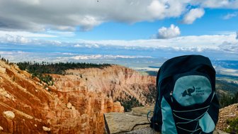 Ein Rucksack steht auf einem Stein, während sich der beeindruckende Bryce Canyon im Hintergrund erstreckt.