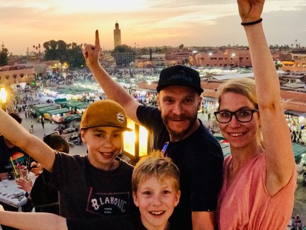 Familie hält einen Moment mit einem Selfie auf dem abendlich Djemaa el Fna in Marrakesch fest – Marokko mit Kindern