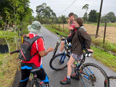 Gemeinsam mit einem lokalen Guide erkundet eine Familie Malakka per Fahrrad – Malaysia & Borneo Familienreise