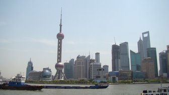 Fähren passieren die Skyline von Pudong auf dem Huangpu-Fluss – China mit Kindern