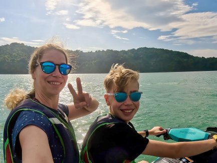 Mutter fährt mit ihrem Kind auf einem Jetski über das Meer vor Langkawi – Malaysia & Borneo Familienreise