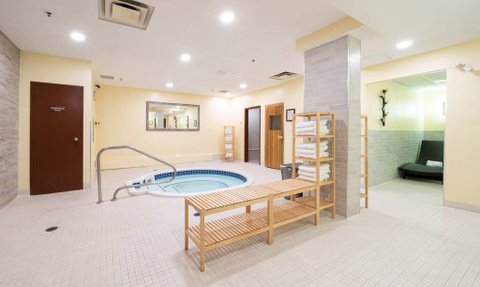 Ein entspannender Wellnessbereich mit einem kleinen Whirlpool, umgeben von einem hellen, modern gestalteten Raum.