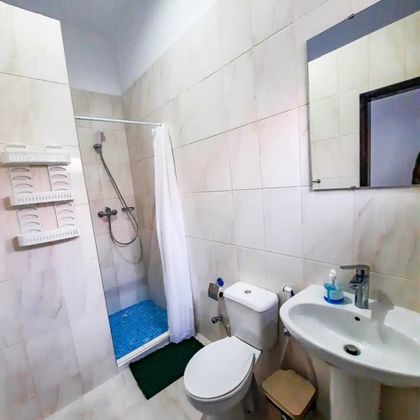 Das Badezimmer verfügt über moderne Sanitäranlagen, einschließlich einer Dusche, Waschbecken und WC, in einem hellen Ambiente.