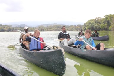 Familiengruppe paddelt bei einer Kanutour auf dem Duluti-See – Tansania Reise mit Kindern