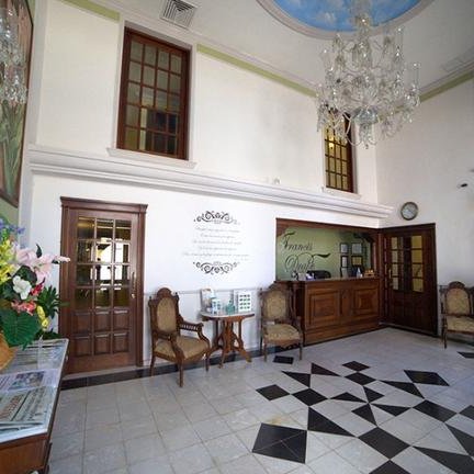 Der Empfangsbereich des Hotels zeigt elegante Möbel und eine stilvolle Einrichtung mit einem Kronleuchter an der Decke.