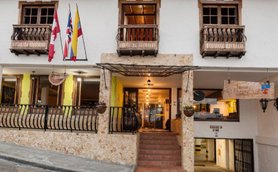 Die Fassade eines charmanten Hotels in Salento, Kolumbien, mit bunten Flaggen und einem einladenden Eingangsbereich.