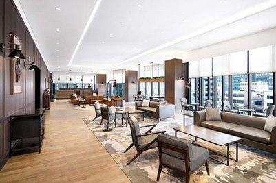 Ein eleganter Lounge-Bereich mit modernen Möbeln, großen Fenstern und einem hellen, einladenden Ambiente.