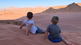 Kinder sitzen auf Düne im Wadi Rum - Jordanien mit Kindern