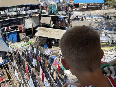 Ein Junge mit einem grünen Trikot beobachtet die Wäsche, die in der Dhobi Ghat von Mumbai zum Trocknen aufgehängt ist.
