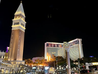 Der beleuchtete Glockenturm des Venetian Hotels erhebt sich majestätisch über die belebte Las Vegas Boulevard bei Nacht.