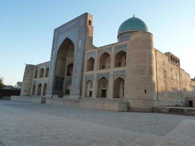 Die Miri-Arab-Madrasa in Buchara zeigt beeindruckende Architektur mit einem markanten blauen Kuppeldach und kunstvollen Verzierungen.