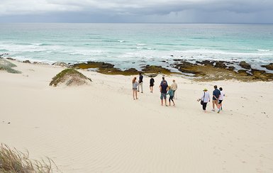 Familie spaziert gemeinsam am weiten Sandstrand des De Hoop Nature Reserve – Garden Route Familienreise