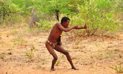 Ein Mann schießt mit einem kleinen Bogen - Namibia Urlaub mit Kindern