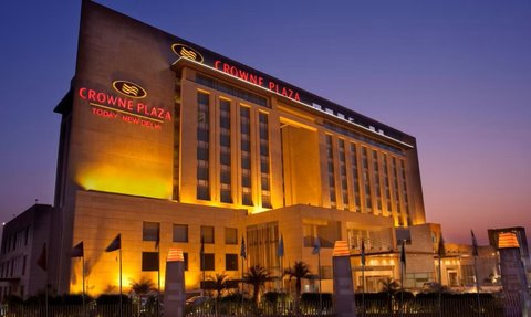 Das Crowne Plaza Hotel in Neu-Delhi erstrahlt in warmem Licht, während der Abendhimmel in sanften Farben leuchtet.
