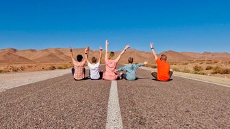 Familie posiert entspannt auf einer Landstraße rund um den Iriki-See – Familienreise nach Marokko