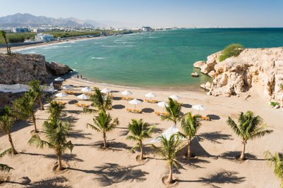 Strand des Crowne Plaza Muscat mit Liegestühlen und Sonnenschirmen – Familienurlaub in Muscat