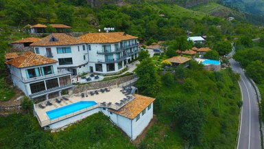 Ein malerisches Resort mit mehreren Gebäuden, umgeben von üppigem Grün und einem einladenden Poolbereich.