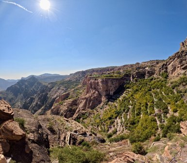 Von einem Aussichtspunkt bietet sich ein spektakulärer Blick über die grünen Terrassenfelder und tiefen Schluchten des Jebel Akhdar – Oman Familienreise