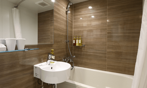 Ein modernes Badezimmer mit einer weißen Badewanne und einem eleganten Waschbecken, umgeben von Holzverkleidung.