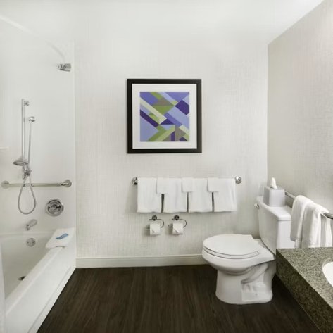 Das moderne Badezimmer verfügt über eine Dusche, eine Badewanne und eine stilvolle Wandgestaltung mit abstrakter Kunst.