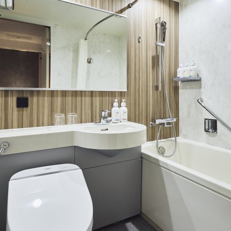 Ein modernes Badezimmer mit einer eleganten Badewanne, einem Waschbecken und stilvollen Holzverkleidungen an den Wänden.