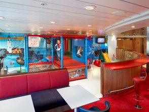 Ein farbenfroher Spielbereich auf einem Schiff mit einem Klettergerüst und einem Rutschenbereich für Kinder.