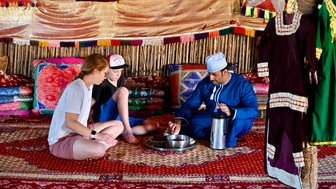 Familie beim gemeinsamen Essen im Camp der Wahiba Sands – Oman Familienreise