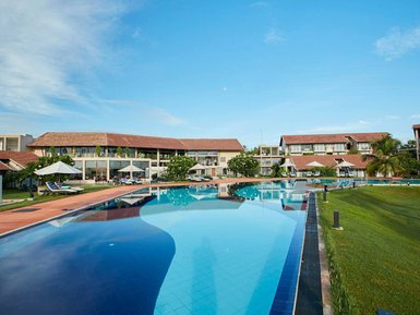 Ein ruhiger Resortbereich in Passikudah, Sri Lanka, mit einem glitzernden Pool und modernen Gebäuden im Hintergrund.