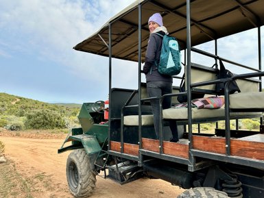 Frau im Safari-Fahrzeug und beobachtet Tiere – Südafrika mit Kindern