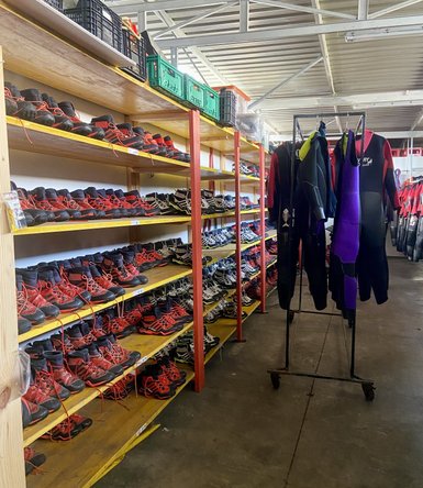 Regale mit einer Vielzahl von Schuhen in Rot und Schwarz, ordentlich auf Regalen angeordnet, bereit für Aktivitäten.
