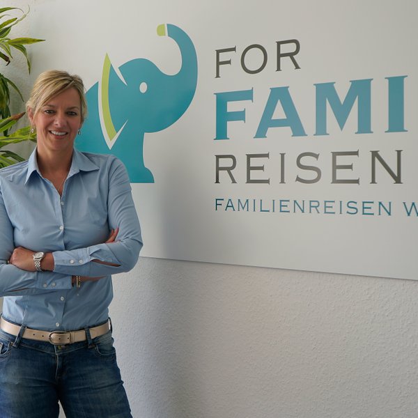 Geschäftsführerin Nadja Albrecht neben For Family Reisen Schild