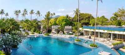 Ein luxuriöser Pool umgeben von Palmen und üppigem Grün, ideal für Entspannung und Erholung in tropischer Umgebung.