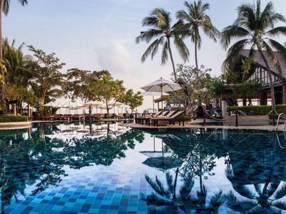 Ein luxuriöser Pool umgeben von Palmen und Liegen, reflektiert die ruhige Atmosphäre des Hotel Peace Resort in Koh Samui.