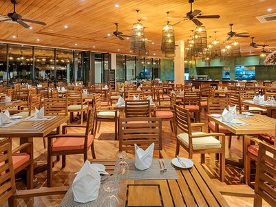 Ein elegantes Restaurant mit Holzmöbeln, das eine einladende Atmosphäre mit warmem Licht und stilvollen Details bietet.
